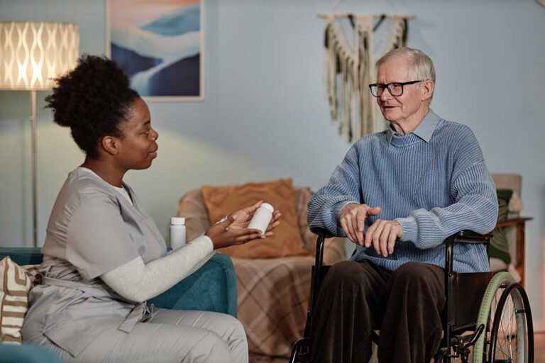 Older adult arranging family photos in a comfortable assisted living room with a supportive relative nearby